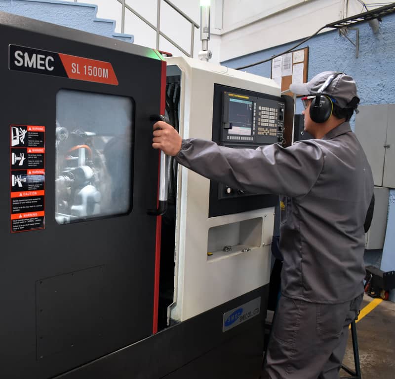 Operario manejando una máquina CNC 1B